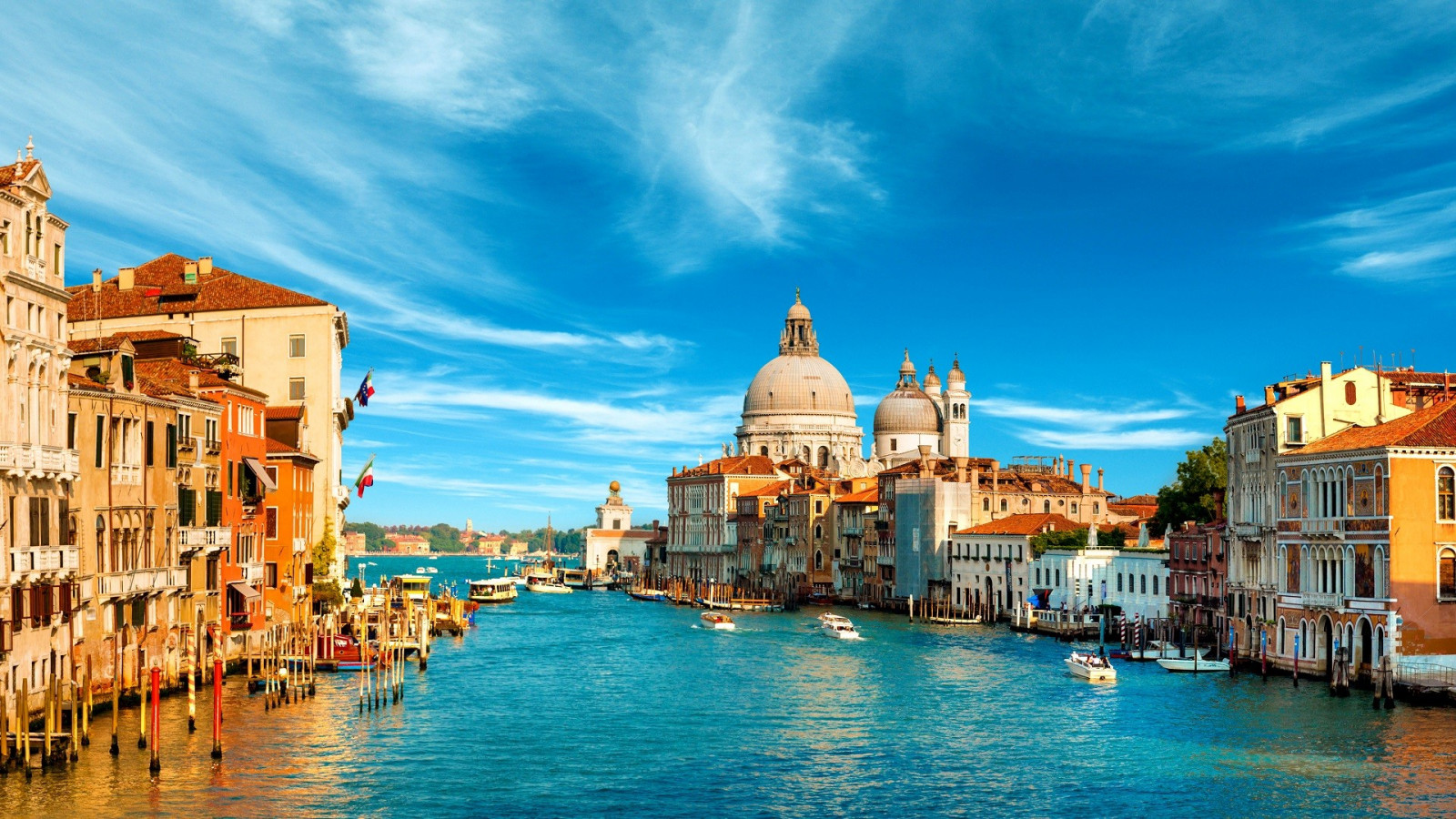 A waterway in Venice, Italy during the day with a very blue sky